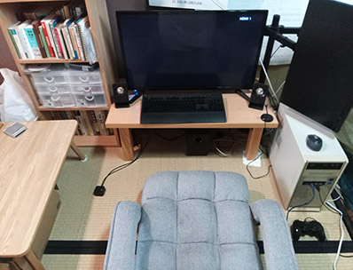 回転座椅子と、その周りの机やPCの写真。